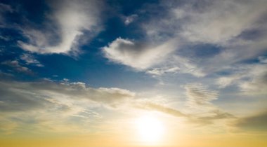 Güneş ışınlarıyla gün batımı, bulutlarla gökyüzü ve güneş.