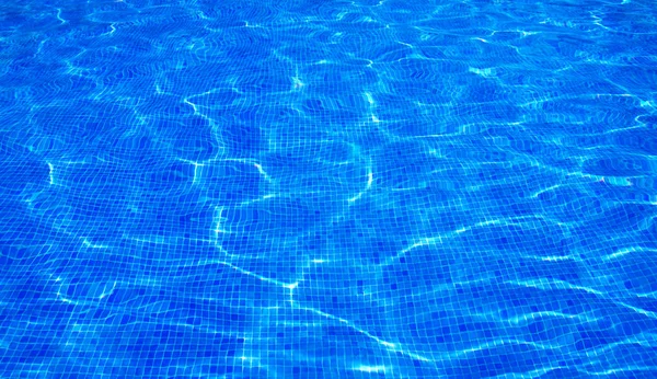Agua azul de la piscina con reflejos solares — Foto de Stock