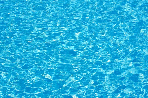 Agua azul de la piscina con reflejos solares — Foto de Stock