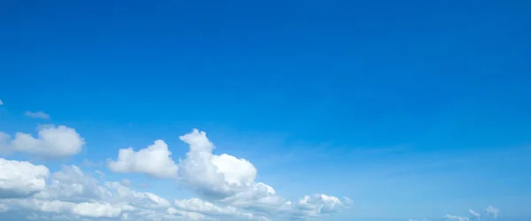 Blauwe lucht achtergrond met kleine wolken — Stockfoto