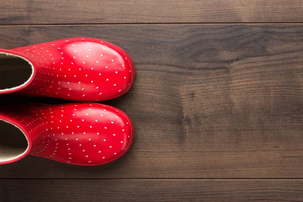 Rote Gummistiefel auf dem Boden — Stockfoto