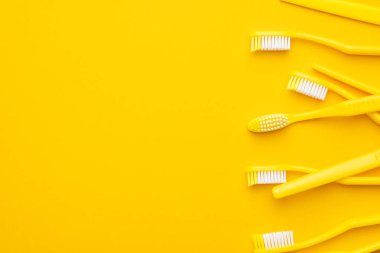 Sarı arkaplanda plastik diş fırçaları