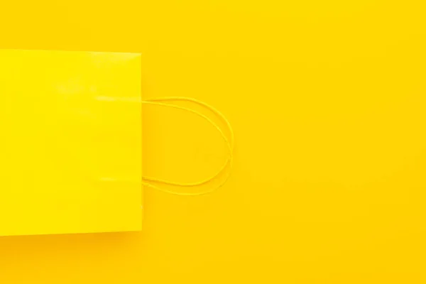 Yellow shopping paper bag on yellow background with copy space. summer sale — Stock Photo, Image