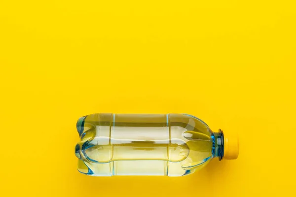 塑料水瓶与黄色盖帽在黄色背景与拷贝空间 — 图库照片