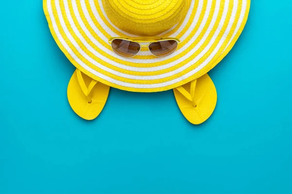 Top view of yellow sunglasses, striped retro hat and flip-flops — Stock Photo, Image