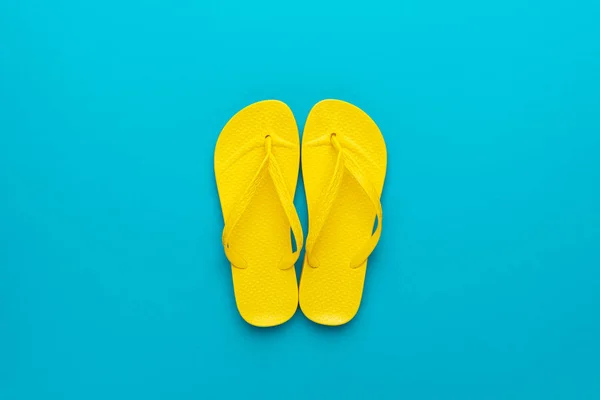 Gele strand flip-flops op de blauwe achtergrond — Stockfoto