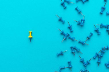 Sarı itme iğnesi mavi arka plan üzerinde kalabalığın konseptinden çıktı