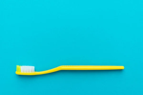 Minimalistisk platt Lay foto av gul tandborste över turkos blå bakgrund — Stockfoto