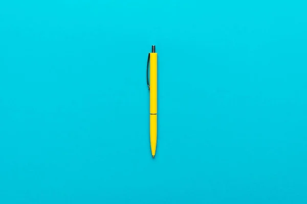 极简主义平面铺设照片黄色圆珠笔在绿松石蓝色背景 — 图库照片