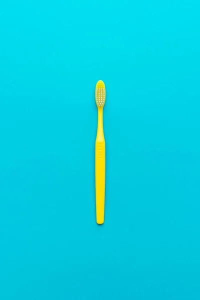 Minimalistisches flaches Lay-Foto einer gelben Zahnbürste über türkisblauem Hintergrund — Stockfoto