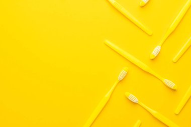 Sarı arkaplanda plastik diş fırçaları