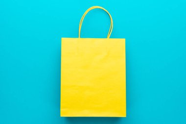 mavi arka plan üzerinde sarı alışveriş kağıt torba üst görünümü