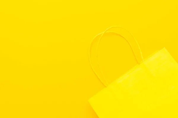 Χάρτινη σακούλα στο κίτρινο φόντο με χώρο αντιγραφής. καλοκαιρινή πώληση — Φωτογραφία Αρχείου