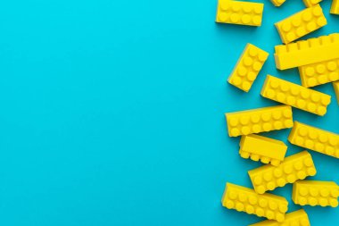 Kopyalama alanı ile turkuaz mavisi arka plan üzerinde sarı plastik yapı taşları