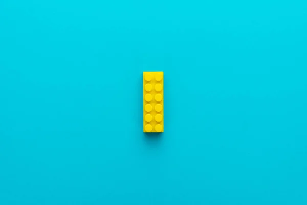 Minimalist flat lay photo of yellow plastic block with copy space