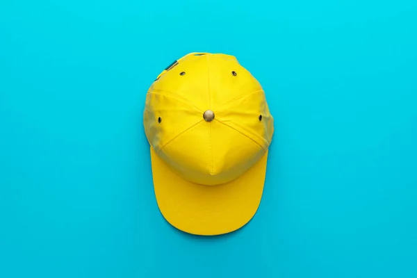 Vue du dessus de la casquette de baseball jaune sur fond bleu turquoise avec espace de copie — Photo