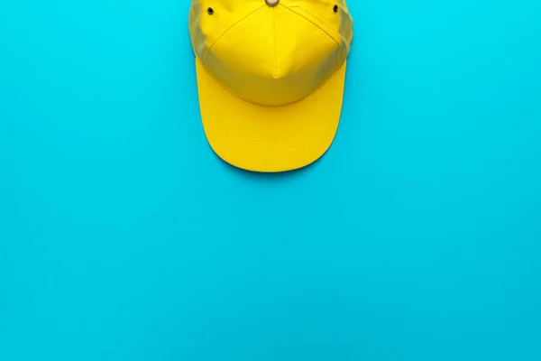 Vue du dessus de la casquette de baseball jaune sur fond bleu torquoise avec espace de copie — Photo