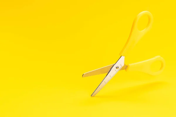 Foto conceptual de tijeras levitantes sobre fondo amarillo con espacio de copia —  Fotos de Stock