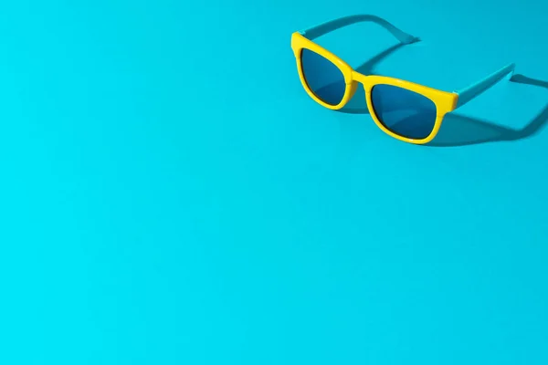 Minimalistyczne zdjęcie okularów przeciwsłonecznych na turkusowym niebieskim tle z kopią przestrzeni — Zdjęcie stockowe