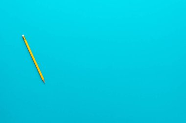 Fotokopi alanı olan turkuaz mavi arkaplan üzerinde sarı kalem fotoğrafı