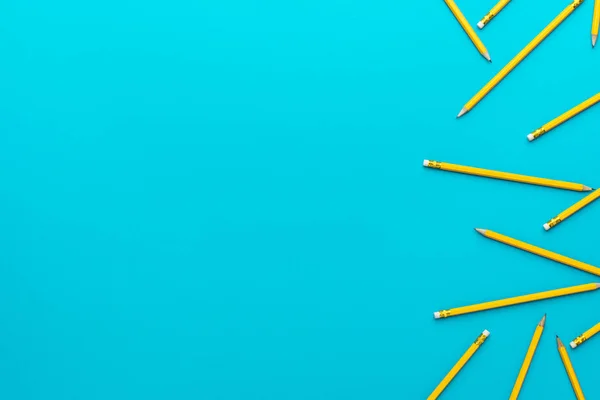 Top view of sharpened pencils over turquoise blue background with copy space