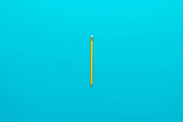 Photo of yellow pencil over turquoise blue background with copy space — Stock Photo, Image