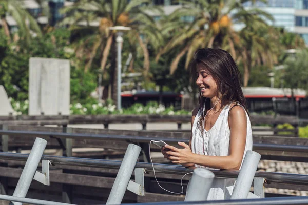 Close-up portret van vrolijke jonge vrouw luisteren naar de muziek op de telefoon — Stockfoto