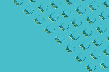 Turkuaz mavi arkaplanda kopyalama alanı olan birçok plastik güneş gözlüğü deseni