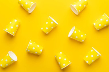 Masanın üzerinde sarı kağıt bardaklar