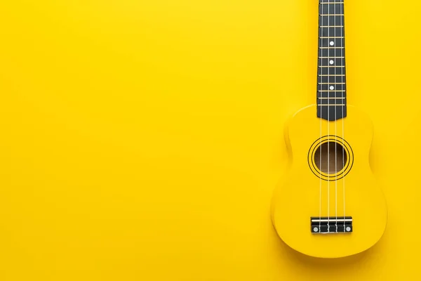 Leżące płaskie zdjęcie żółtego ukulele z przestrzenią do kopiowania — Zdjęcie stockowe