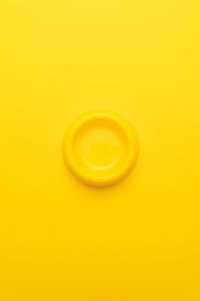 Foto minimalista de un cuenco amarillo vacío sobre fondo amarillo — Foto de Stock