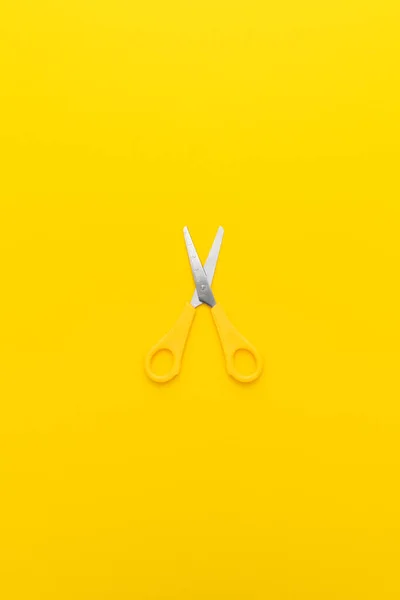 Flat lay vertical shot of opened yellow scissors with central composition — Stock Photo, Image