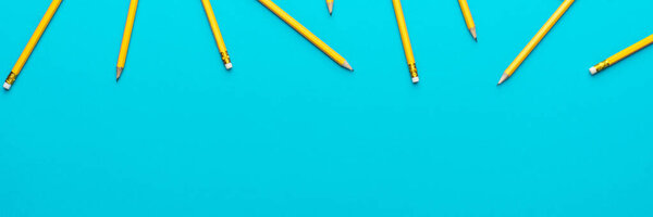 Top view of sharpened pencils over turquoise blue background with copy space