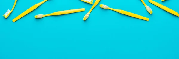 Ovanifrån av gula tandborstar över turkos blå bakgrund med kopia utrymme — Stockfoto