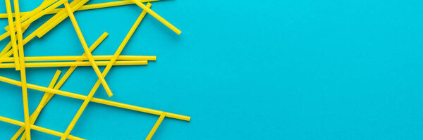 Top view of cocktail straws on turquoise blue background with copy space