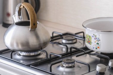 Bir gaz sobası görüntüsünü kapat su ısıtıcısı ve pan ile