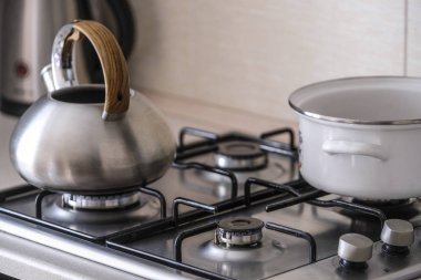 Bir gaz sobası görüntüsünü kapat su ısıtıcısı ve pan ile