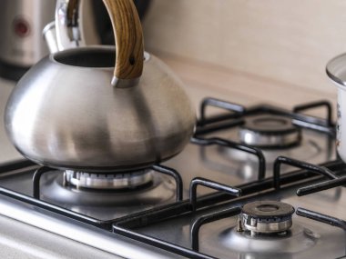 Bir gaz sobası görüntüsünü kapat su ısıtıcısı ve pan ile