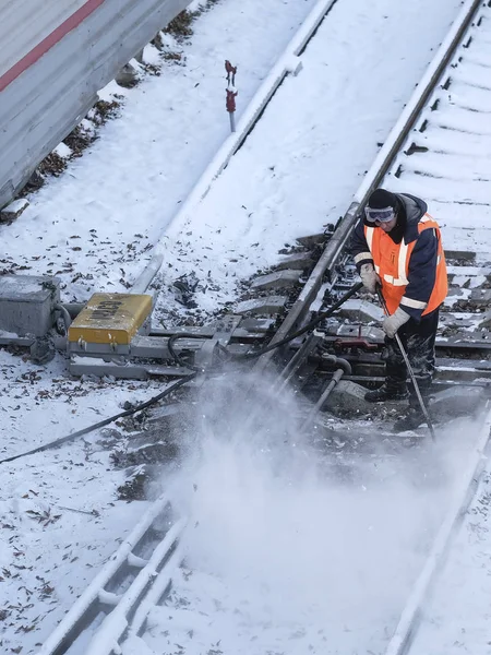 the railway worker cleans a railway track