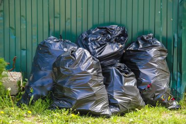 çit yakınındaki çöp torbaları görüntü