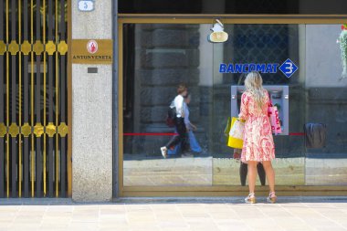 Padova, İtalya - 4 Haziran 2019: Kız Padova, İtalya'nın merkezindeki bir Atm'den para alıyor