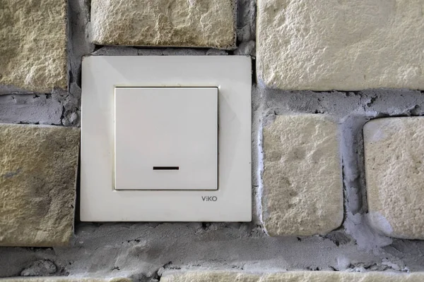 The image of an electric switch on a brick wall