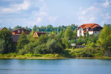 Tula region, Russia - September, 4, 2019: country landscape with the image of a village on a lake bank in Tula region, Russia