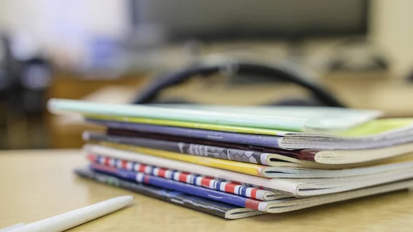 image of a stack of notebooks on the teacher's desk