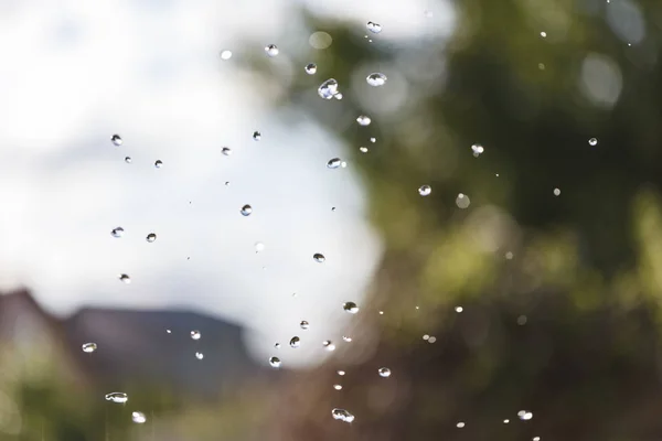Water drops in the air against the sky — Stock Photo, Image