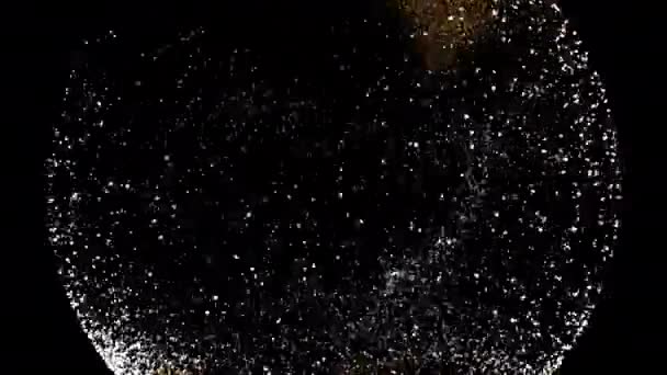 Leuchtend goldene Schneekugel mit Schneefall-Animation auf schwarzem Hintergrund. — Stockvideo