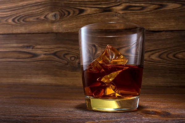 苏格兰威士忌的木制背景与版权空间 陈年老旧的台面 有亮点和一杯烈性酒 — 图库照片