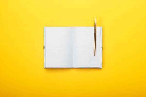 Notizbuch und Stift auf gelbem Hintergrund — Stockfoto