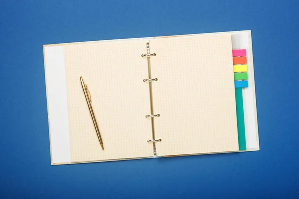 Cuaderno y pluma sobre fondo azul — Foto de Stock