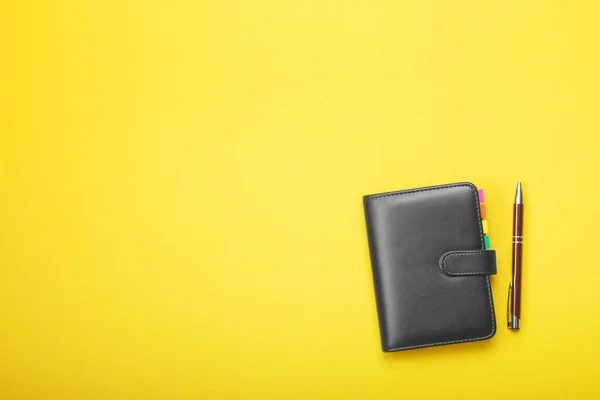 Cuaderno y pluma sobre un fondo amarillo — Foto de Stock